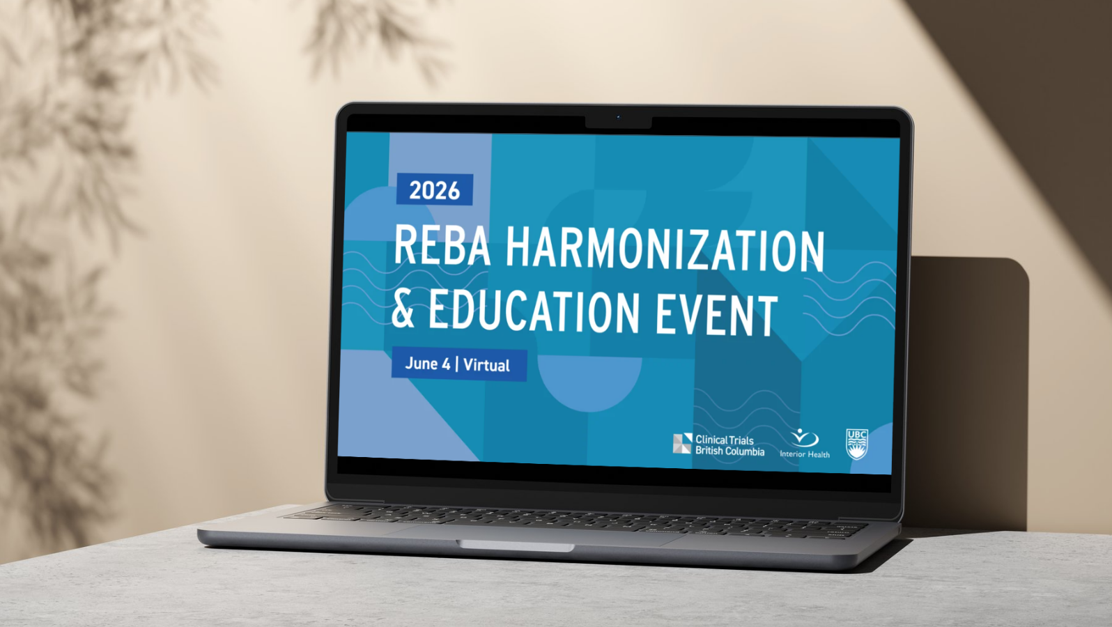 An open laptop that shows an opening slide in a presentation for the REBA Harmonization and Education Event 2026, held on June 4. The Clinical Trials British Columbia, Interior Health and UBC logos are shown on the slide. Behind the laptop is a beige wall with natural light.