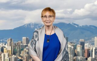 Dr. Barbara McGillivray smiling against a city skyline.